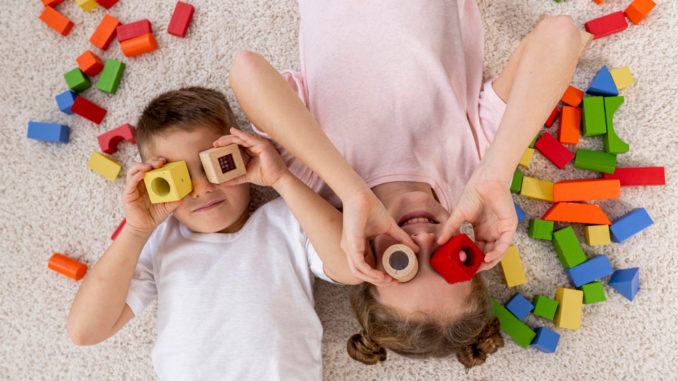 Kinder beschäftigen Zwei Kinder spielen mit Bauklötzen